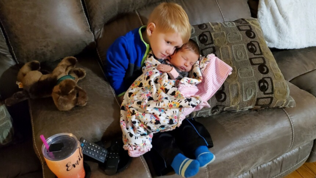 Image of thriving in the mess author's son holding his baby sister at their first meeting bringing her home from the hospital.