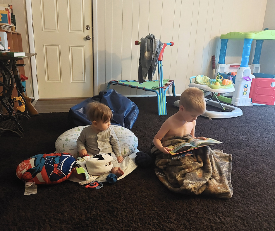Image of the author's children playing/reading on the floor.