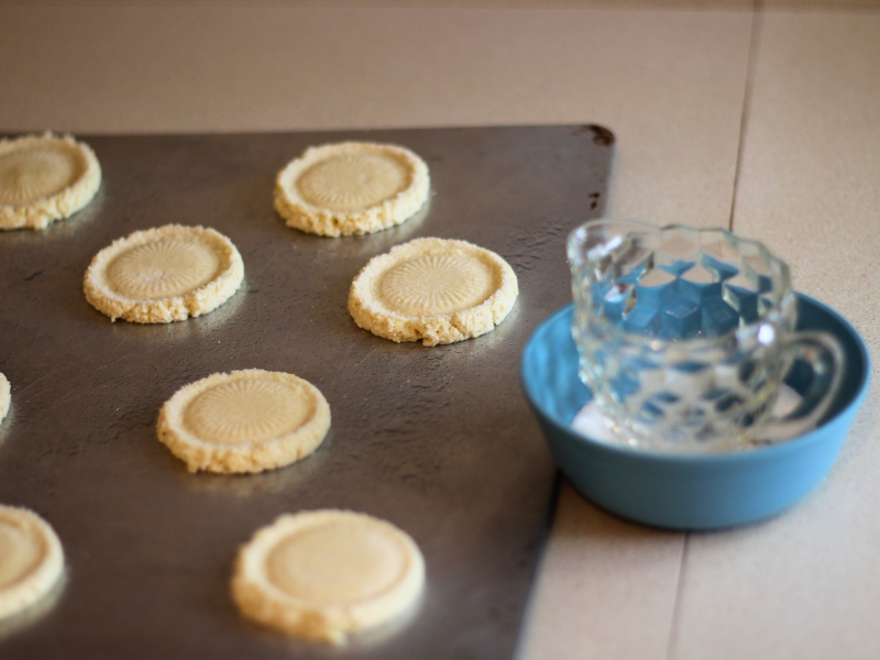 Old fashioned sugar cookie dough that's been gently pressed onto the cookie sheet with an old crystal glass dipped in sugar.