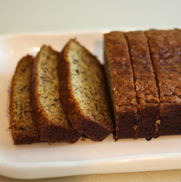Image of freshly baked banana bread sliced on a platter.