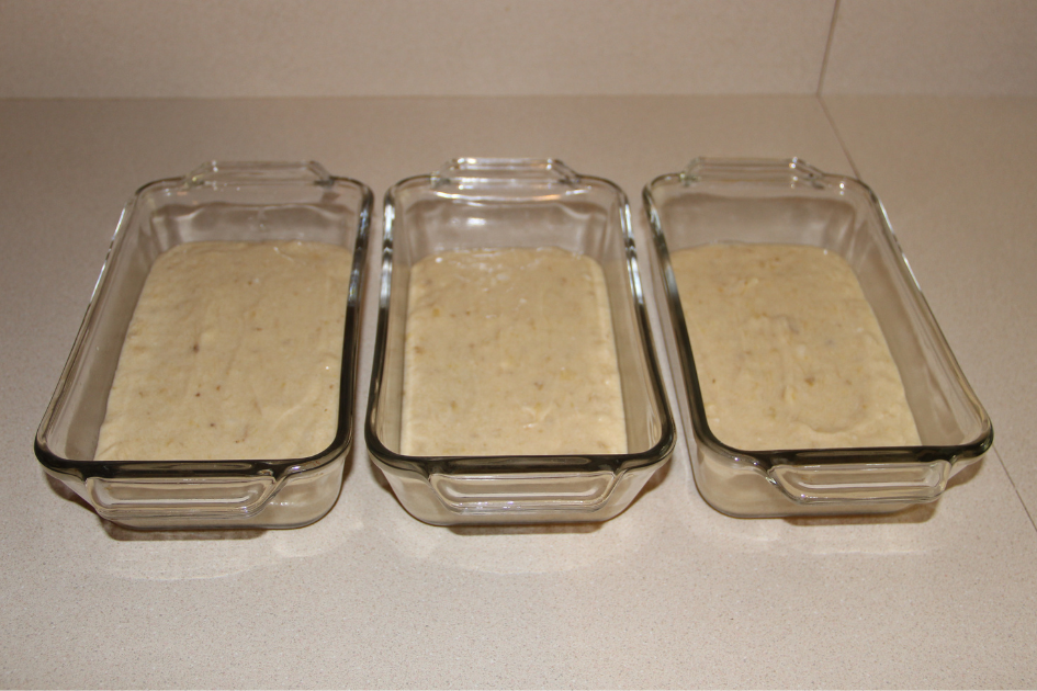 Image of banana bread dough in 3 glass loaf dishes.