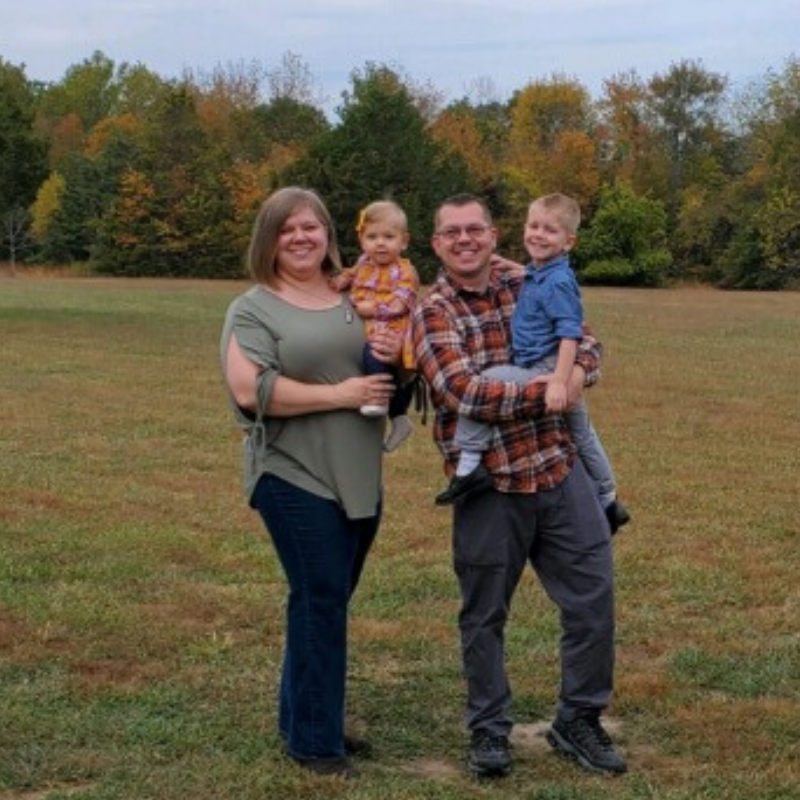 Image of author with husband, Shane, and youngest son and daughter in a field.