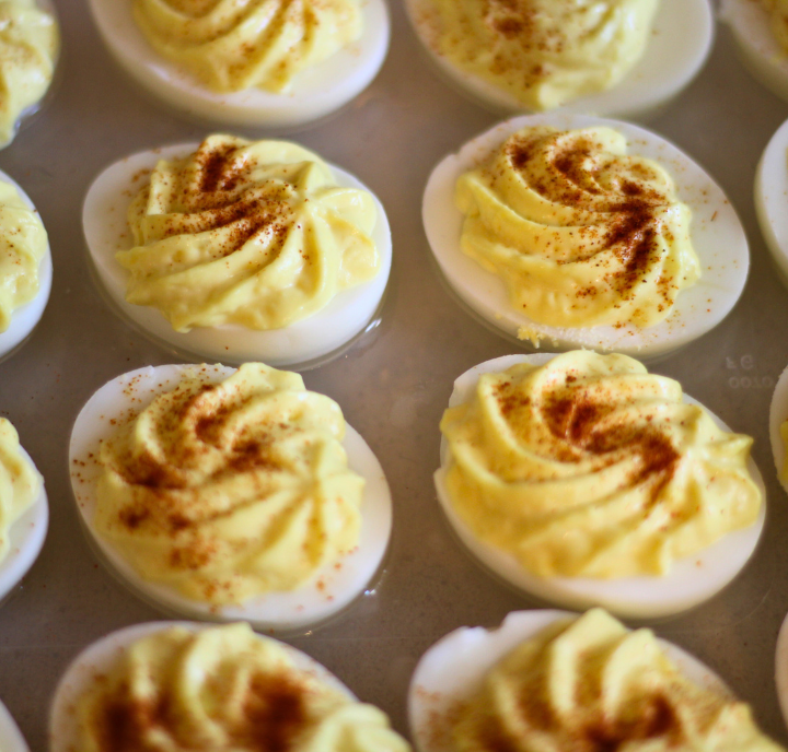 Close up image of 2 rows of classic deviled eggs sprinkled with paprika