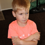 Image of strong-willed child crossing his arms and pouting